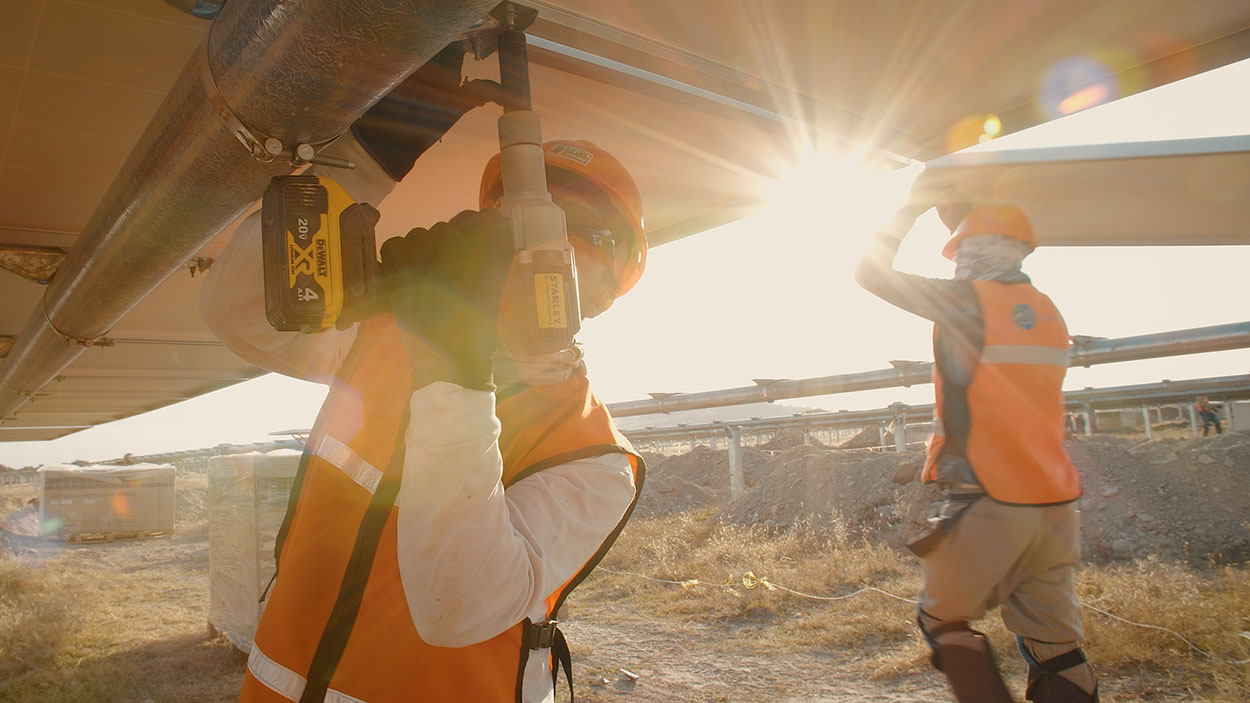 Arbeiter, die Solarmodule mit dem kabellosen Neobolt-Werkzeug installieren